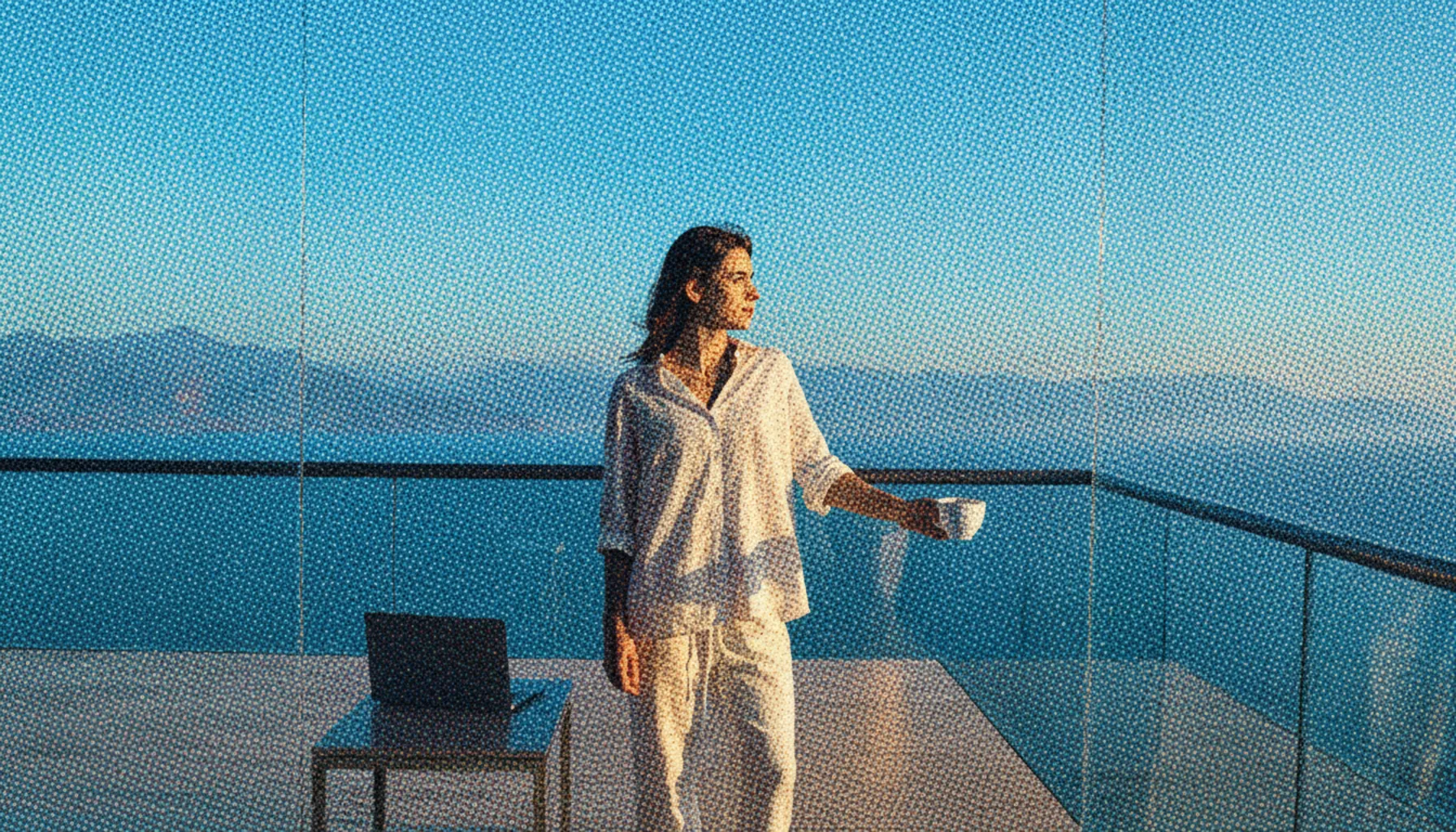 Person enjoying time freedom on a balcony looking at a scenic view symbolizing financial autonomy.
